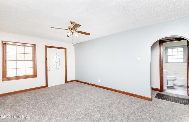 1108 Dresden Ave, Louisville, KY 40215 - carpeted empty room featuring arched walkways, a ceiling fan, baseboards, and a textured ceiling