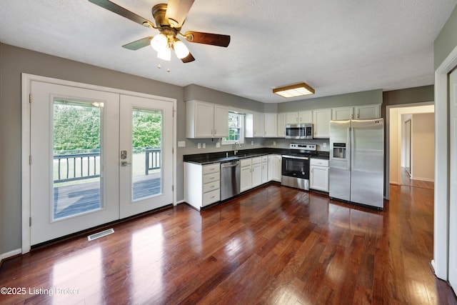 9400 Minute Men Ct, Louisville, KY 40214 - kitchen with appliances with stainless steel finishes, dark countertops, french doors, dark wood finished floors, and white cabinetry