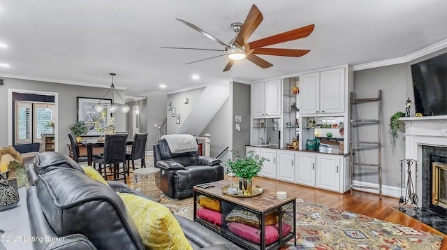 5531 Forest Lake Dr, Prospect, KY 40059 - living room with a ceiling fan, a fireplace with flush hearth, crown molding, light wood-style flooring, and stairs