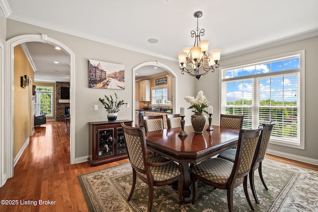 15323 Royal Troon Ave, Louisville, KY 40245 - dining area featuring arched walkways, a chandelier, light wood-type flooring, crown molding, and baseboards