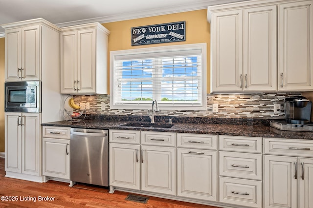 15323 Royal Troon Ave, Louisville, KY 40245 - kitchen with appliances with stainless steel finishes, a sink, light wood-style flooring, tasteful backsplash, and crown molding