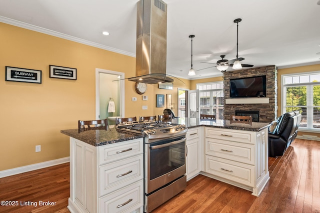 15323 Royal Troon Ave, Louisville, KY 40245 - kitchen featuring stainless steel gas range, island range hood, open floor plan, a fireplace, and a ceiling fan
