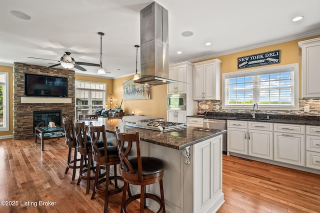 15323 Royal Troon Ave, Louisville, KY 40245 - kitchen with island range hood, crown molding, a ceiling fan, open floor plan, and a kitchen breakfast bar