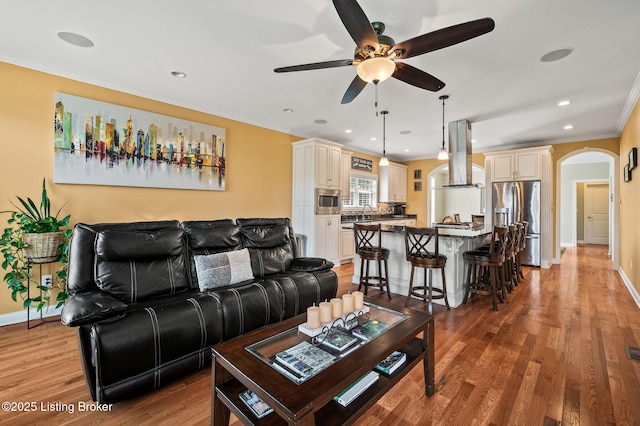 15323 Royal Troon Ave, Louisville, KY 40245 - living room with arched walkways, ceiling fan, ornamental molding, light wood finished floors, and baseboards