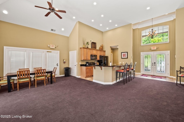 15323 Royal Troon Ave, Louisville, KY 40245 - kitchen with high vaulted ceiling, black appliances, french doors, dark countertops, and a kitchen breakfast bar