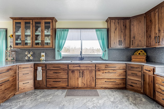 3412 Boyds Knob Rd, Munfordville, KY 42765 - kitchen featuring a sink, tasteful backsplash, brown cabinetry, light stone counters, and stone finish flooring