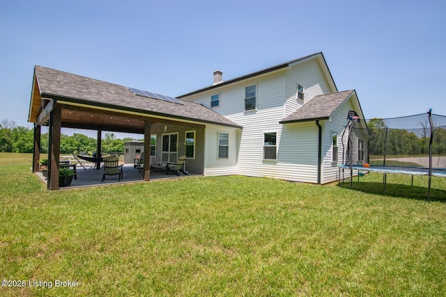 3412 Boyds Knob Rd, Munfordville, KY 42765 - back of house with a trampoline, a patio area, solar panels, and a lawn