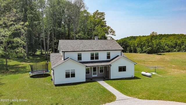 3412 Boyds Knob Rd, Munfordville, KY 42765 - view of front of house featuring a trampoline, a front yard, roof with shingles, and a forest view