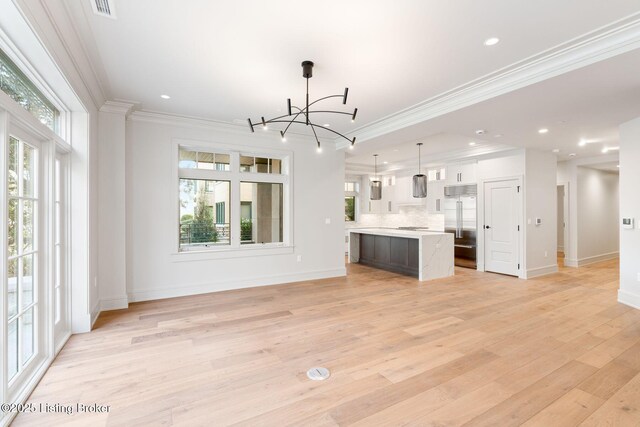 1576 Cherokee Rd Unit 1, Louisville, KY 40205 - unfurnished living room featuring ornamental molding, light wood finished floors, healthy amount of natural light, baseboards, and a chandelier