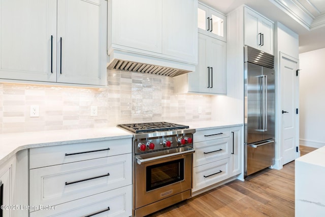 1576 Cherokee Rd Unit 1, Louisville, KY 40205 - kitchen featuring premium appliances, white cabinets, light wood finished floors, light stone countertops, and ornamental molding