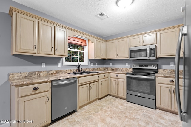 103 Maggie Ln, Bardstown, KY 40004 - kitchen featuring appliances with stainless steel finishes, a sink, cream cabinetry, a textured ceiling, and light brown cabinets