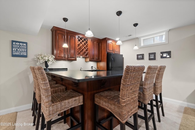 6209 Interlaken Way, Prospect, KY 40059 - kitchen with freestanding refrigerator, baseboards, a breakfast bar, dark countertops, and pendant lighting