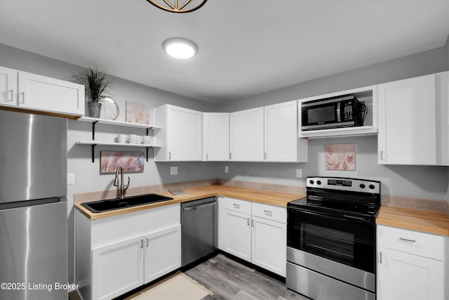 2300 Dundee Rd Unit 2, Louisville, KY 40205 - kitchen featuring stainless steel appliances, a sink, butcher block countertops, white cabinets, and open shelves