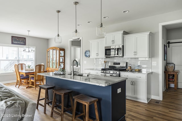 2824 Alder Wood Ln, La Grange, KY 40031 - kitchen with appliances with stainless steel finishes, a sink, backsplash, dark wood-type flooring, and a breakfast bar