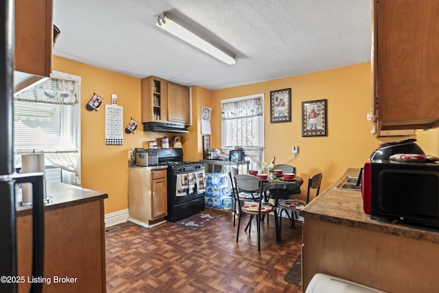 2733 Dumesnil St, Louisville, KY 40211 - kitchen featuring black appliances, under cabinet range hood, a textured ceiling, brown cabinets, and glass insert cabinets
