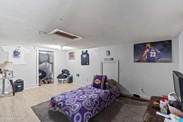 2733 Dumesnil St, Louisville, KY 40211 - bedroom featuring attic access, wood finished floors, and a textured ceiling