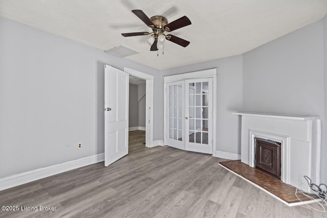 2733 Dumesnil St, Louisville, KY 40211 - unfurnished living room with wood finished floors, a fireplace with raised hearth, french doors, and a ceiling fan