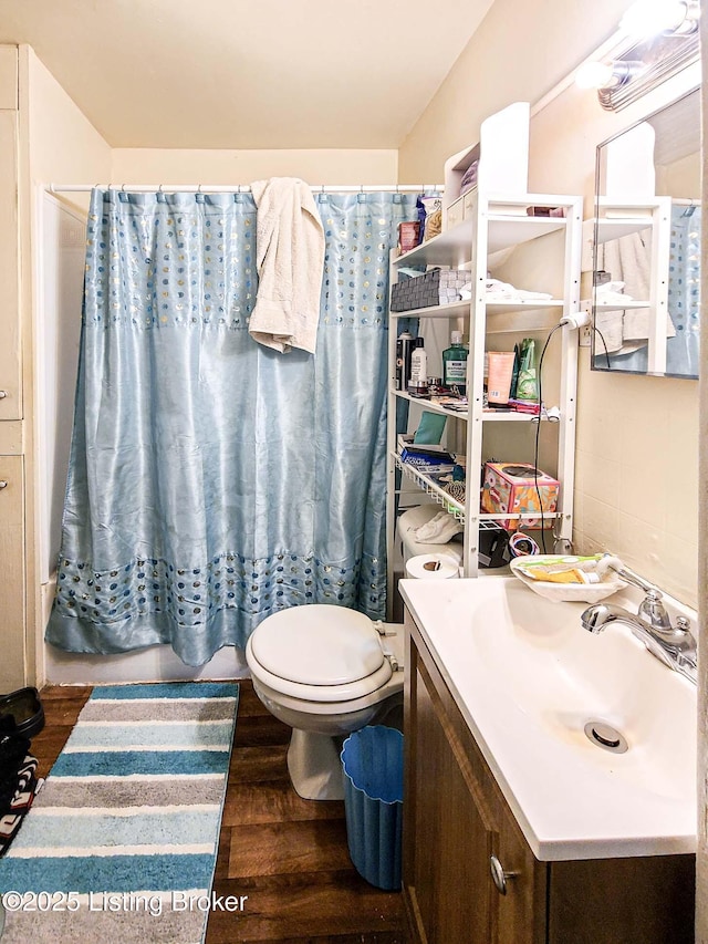 513 Camp St, Louisville, KY 40203 - full bathroom with wood finished floors, vanity, toilet, and a shower with curtain