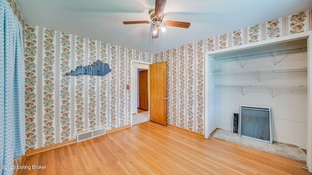 316 Short Rd, Louisville, KY 40207 - unfurnished living room with wood finished floors, wallpapered walls, baseboards, a ceiling fan, and a fireplace