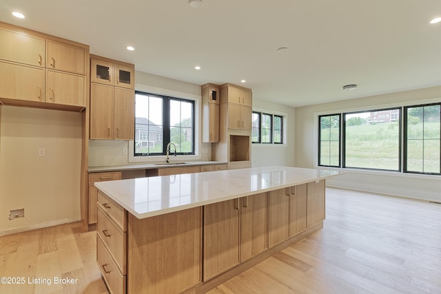 6609 Clore Lake Rd, Crestwood, KY 40014 - kitchen with light wood-style floors, a kitchen island, recessed lighting, glass insert cabinets, and light brown cabinetry