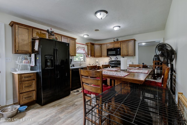 14499 S S Highway 259, Leitchfield, KY 42754 - kitchen with black appliances, light wood-style floors, light countertops, brown cabinetry, and a textured ceiling