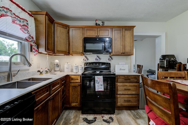 14499 S S Highway 259, Leitchfield, KY 42754 - kitchen with black appliances, light wood-style flooring, light countertops, and brown cabinetry