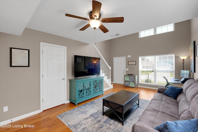 204 Greenleaf Dr, Elizabethtown, KY 42701 - living room featuring stairway, a ceiling fan, plenty of natural light, wood finished floors, and a towering ceiling