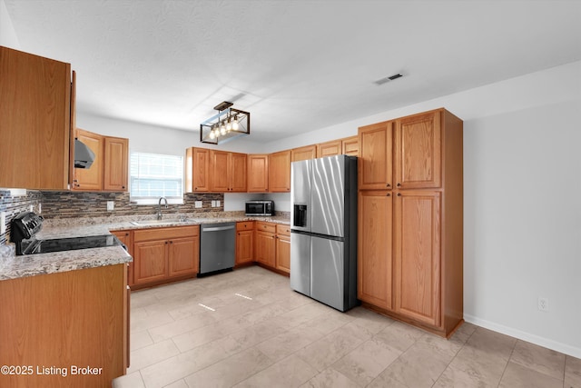 204 Greenleaf Dr, Elizabethtown, KY 42701 - kitchen with stainless steel appliances, a sink, light stone counters, backsplash, and baseboards