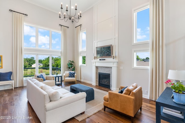17716 Shakes Creek Dr, Fisherville, KY 40023 - living room featuring a towering ceiling, a fireplace with flush hearth, a chandelier, dark wood-type flooring, and baseboards