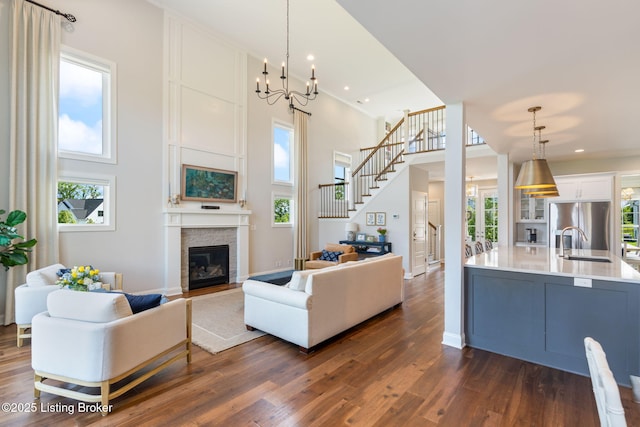 17716 Shakes Creek Dr, Fisherville, KY 40023 - living room with dark wood-style floors, plenty of natural light, a glass covered fireplace, stairway, and a towering ceiling