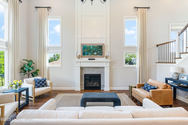 17716 Shakes Creek Dr, Fisherville, KY 40023 - living room featuring a towering ceiling, a fireplace, wood finished floors, stairs, and baseboards