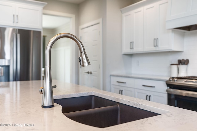 17716 Shakes Creek Dr, Fisherville, KY 40023 - kitchen with appliances with stainless steel finishes, under cabinet range hood, light stone countertops, white cabinets, and a sink