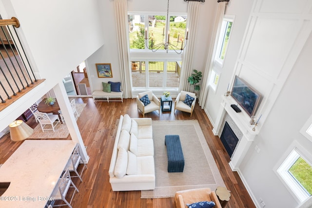 17716 Shakes Creek Dr, Fisherville, KY 40023 - living area featuring a towering ceiling, stairway, hardwood / wood-style floors, a fireplace, and a chandelier