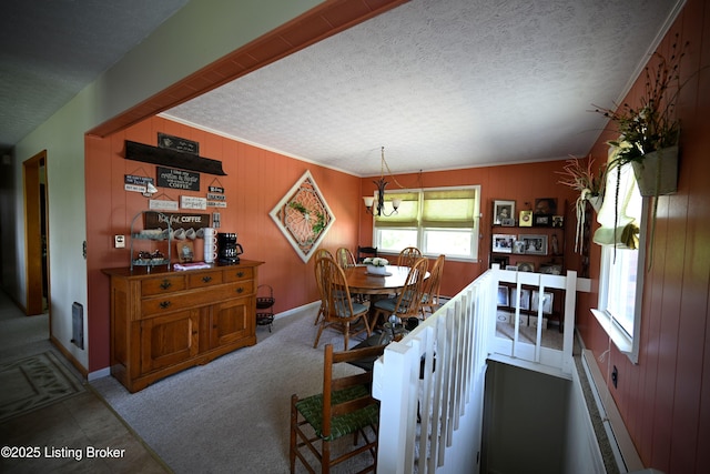 1025 Lake Rd, Campbellsburg, KY 40011 - dining area with a textured ceiling, wooden walls, a chandelier, carpet floors, and baseboards