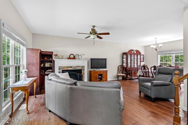162 Penny Royal Ln, Brandenburg, KY 40108 - living room with a chandelier, light wood-style flooring, a ceiling fan, and a stone fireplace