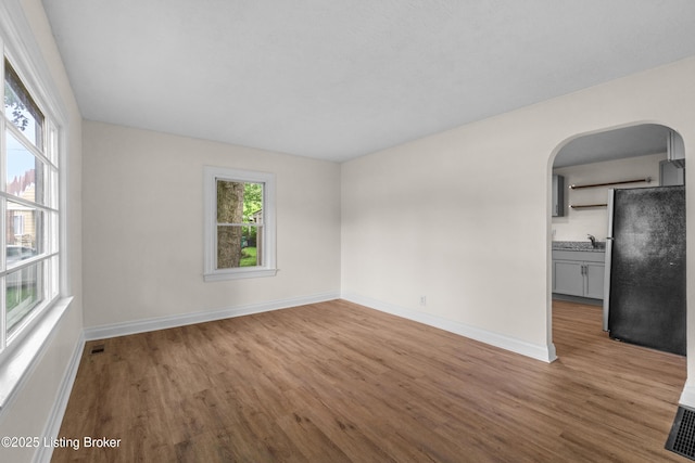 4725 Kiefer Rd, Louisville, KY 40216 - spare room with arched walkways, wood finished floors, and baseboards
