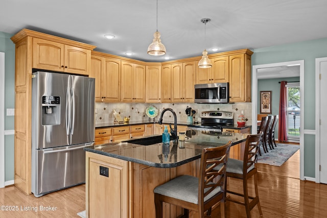 6400 Cedar Branch Ct, Louisville, KY 40291 - kitchen featuring appliances with stainless steel finishes, light wood-type flooring, a breakfast bar area, decorative backsplash, and recessed lighting