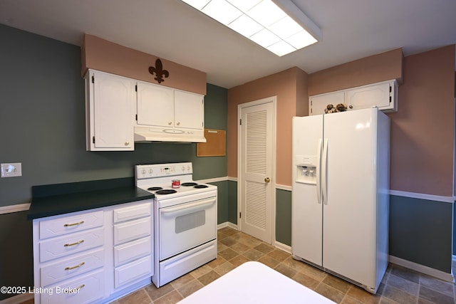 4913 D Lue Ct, Louisville, KY 40216 - kitchen with white appliances, under cabinet range hood, white cabinetry, baseboards, and dark countertops