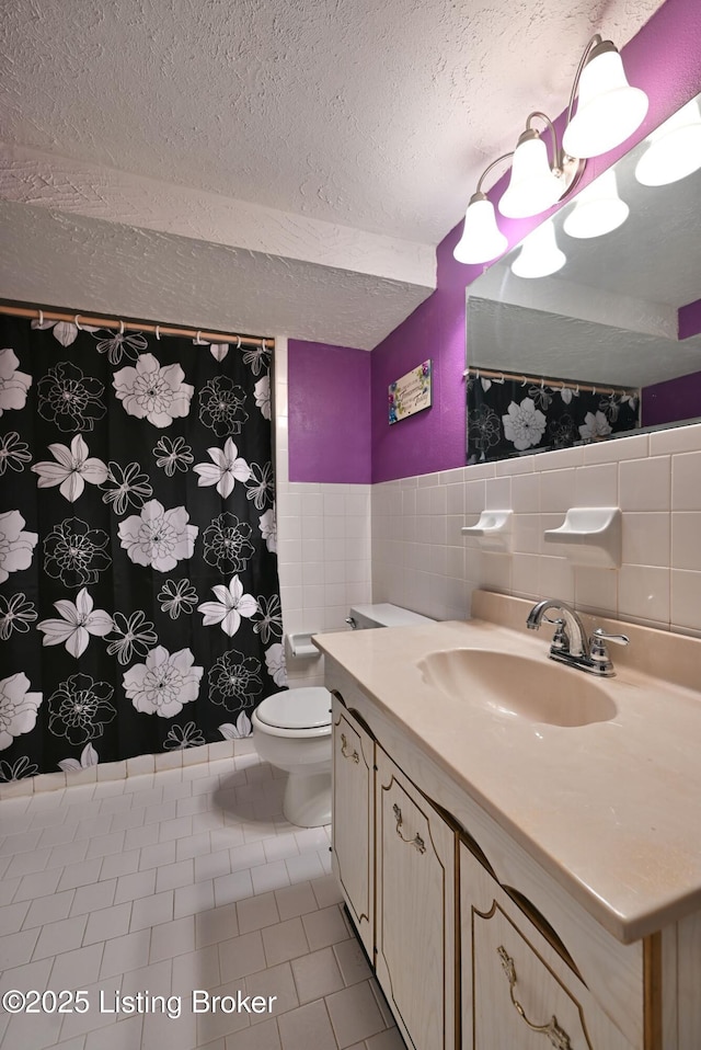 4913 D Lue Ct, Louisville, KY 40216 - full bathroom featuring tile walls, a textured ceiling, vanity, tile patterned flooring, and toilet