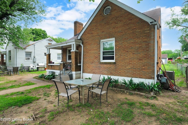 315 N 27th St, Louisville, KY 40212 - back of property featuring brick siding, a chimney, outdoor dining space, and a patio area