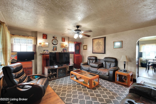 315 N 27th St, Louisville, KY 40212 - living area featuring a textured wall, arched walkways, ceiling fan, a textured ceiling, and healthy amount of natural light