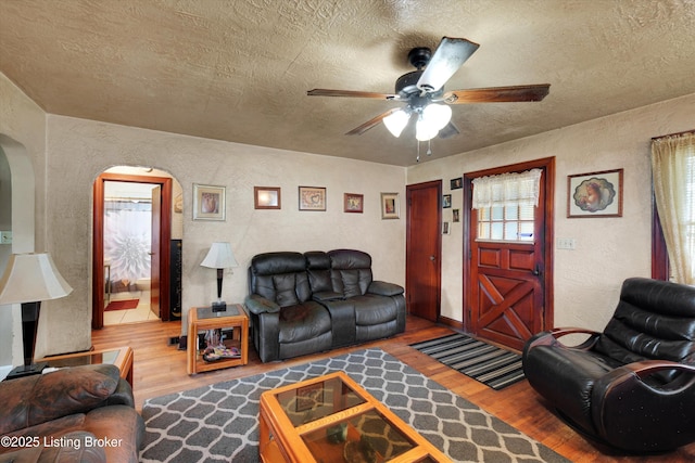 315 N 27th St, Louisville, KY 40212 - living room featuring arched walkways, wood finished floors, a textured wall, a ceiling fan, and a textured ceiling