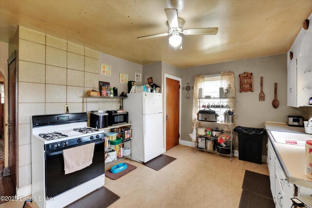 315 N 27th St, Louisville, KY 40212 - kitchen featuring gas range oven, freestanding refrigerator, stainless steel microwave, a ceiling fan, and light countertops