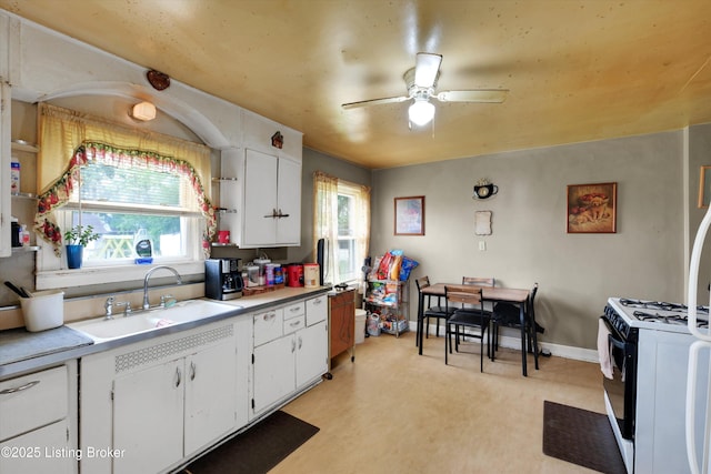 315 N 27th St, Louisville, KY 40212 - kitchen with a sink, ceiling fan, white cabinetry, and plenty of natural light