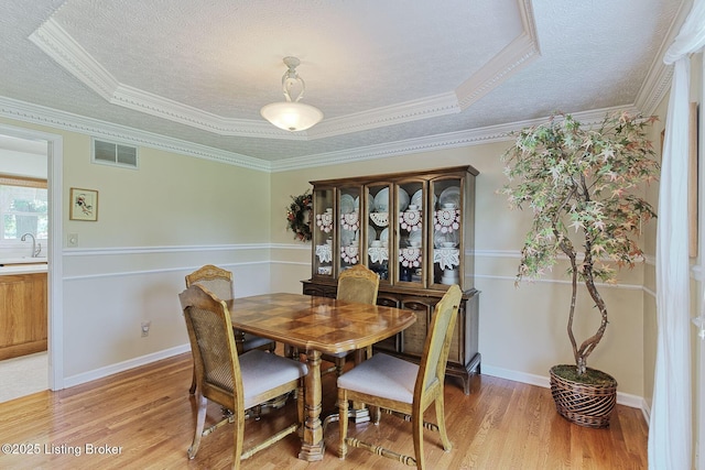 348 Old Stone Dr, Simpsonville, KY 40067 - dining room featuring a textured ceiling, light wood finished floors, and ornamental molding