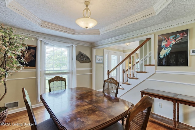348 Old Stone Dr, Simpsonville, KY 40067 - dining room featuring a textured ceiling, wood finished floors, stairs, crown molding, and a tray ceiling