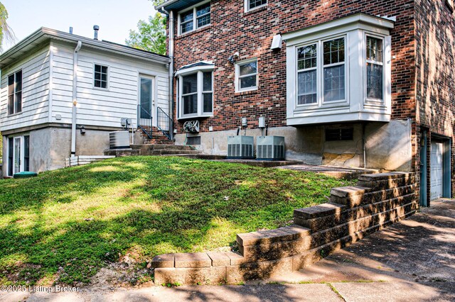 3325 Chenoweth Run Rd, Louisville, KY 40299 - back of house featuring entry steps, driveway, cooling unit, an attached garage, and brick siding