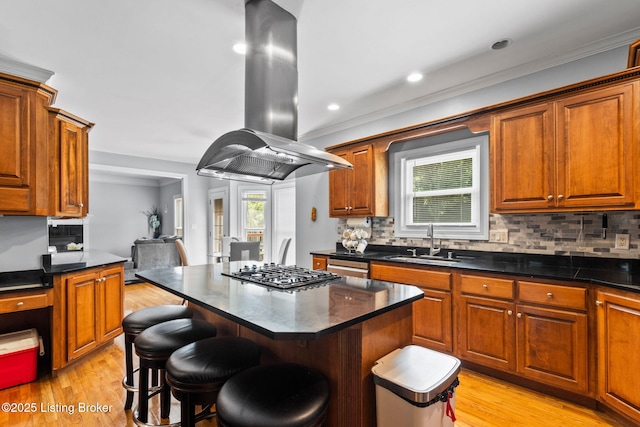 17411 Polo Run Ln, Louisville, KY 40245 - kitchen with island exhaust hood, a sink, stainless steel gas cooktop, tasteful backsplash, and light wood-style flooring