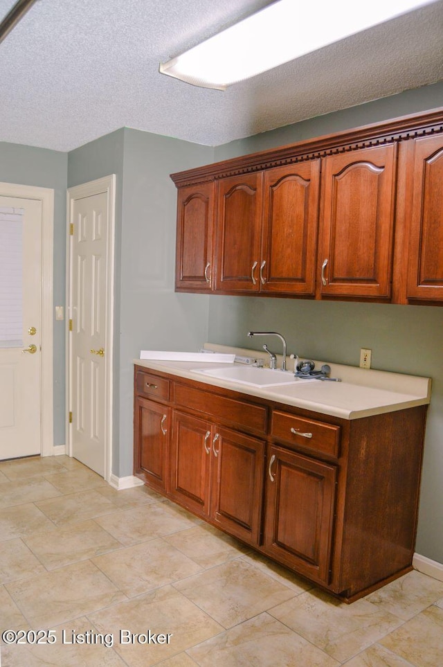 166 Castleton Dr, Bardstown, KY 40004 - kitchen featuring a sink, light countertops, baseboards, and brown cabinets