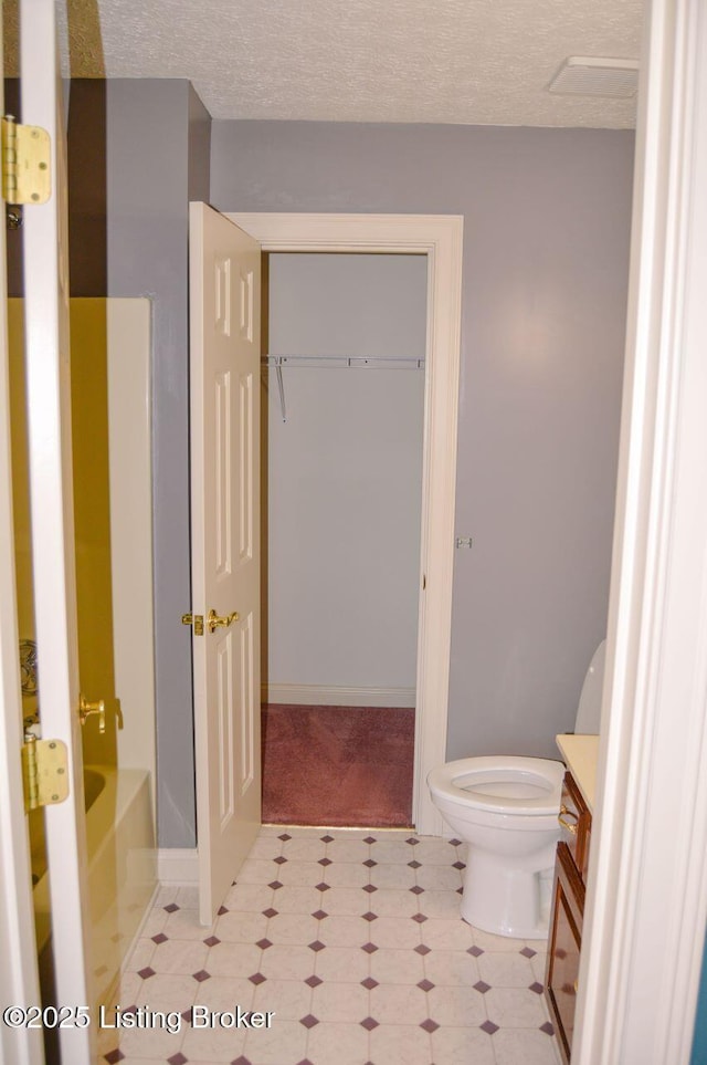 166 Castleton Dr, Bardstown, KY 40004 - bathroom featuring vanity, toilet, tile patterned floors, a textured ceiling, and a tub to relax in